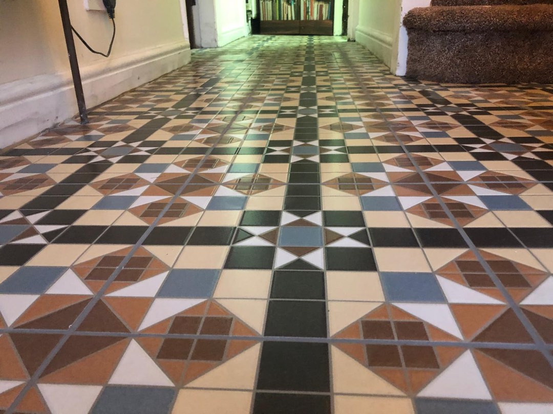 Restored Victorian geometric mosaic hallway floor in terracotta, slate and cream tiles